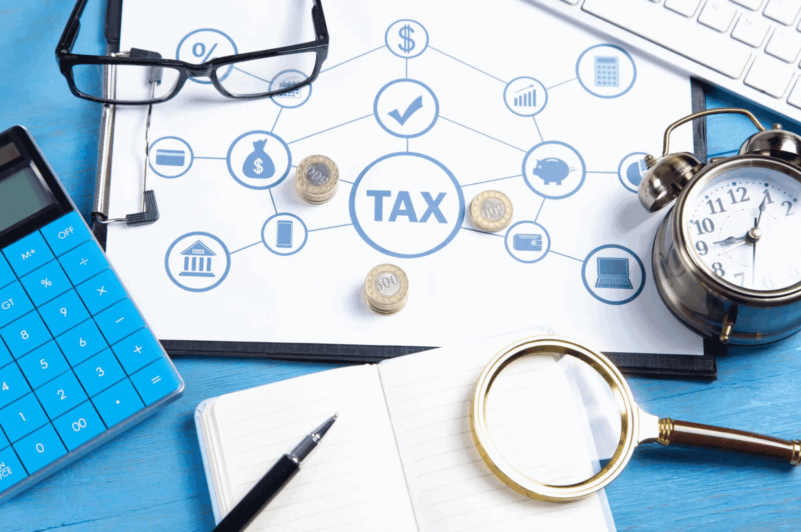 Tax planning concept with coins, calculator, and notebook on desk.