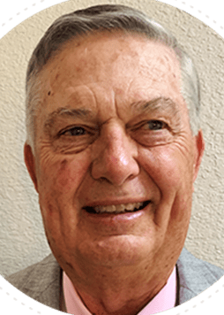 Smiling elderly man with wrinkles and short gray hair.