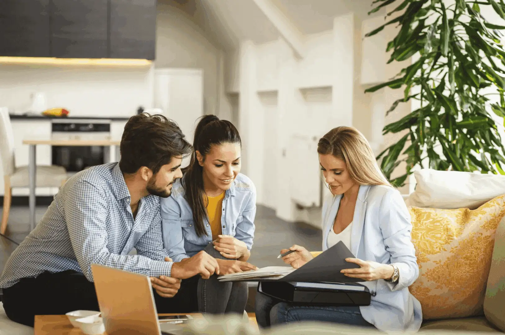 Three people collaborating over documents in a modern office.